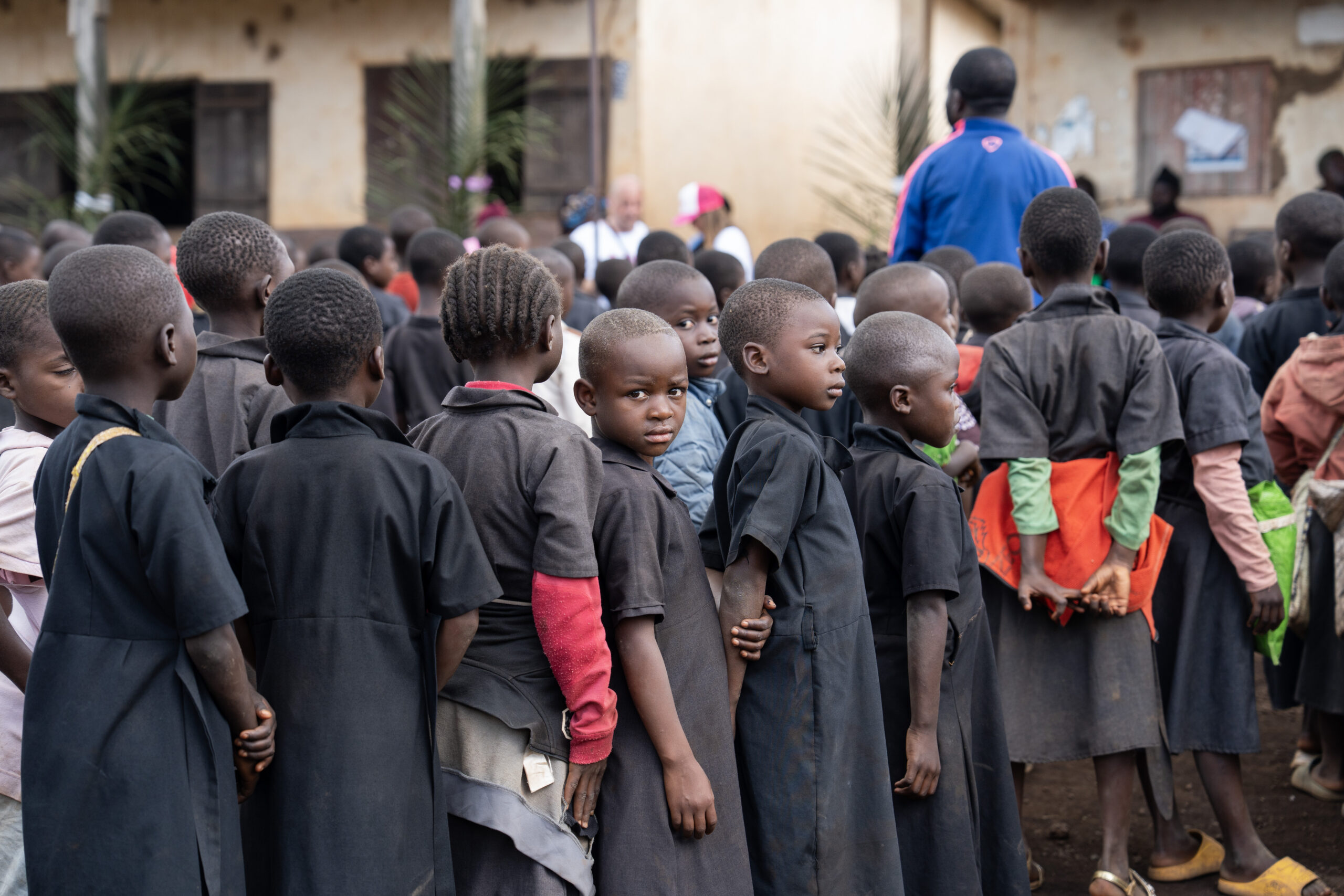 Alunni di una scuola rurale in Camerun riuniti nel cortile durante un'attività del progetto A scuola di igiene e rispetto.